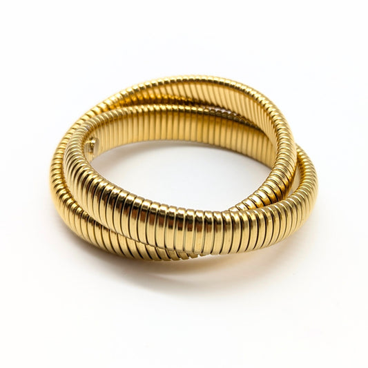 Overlapping gold bangles with ridged texture