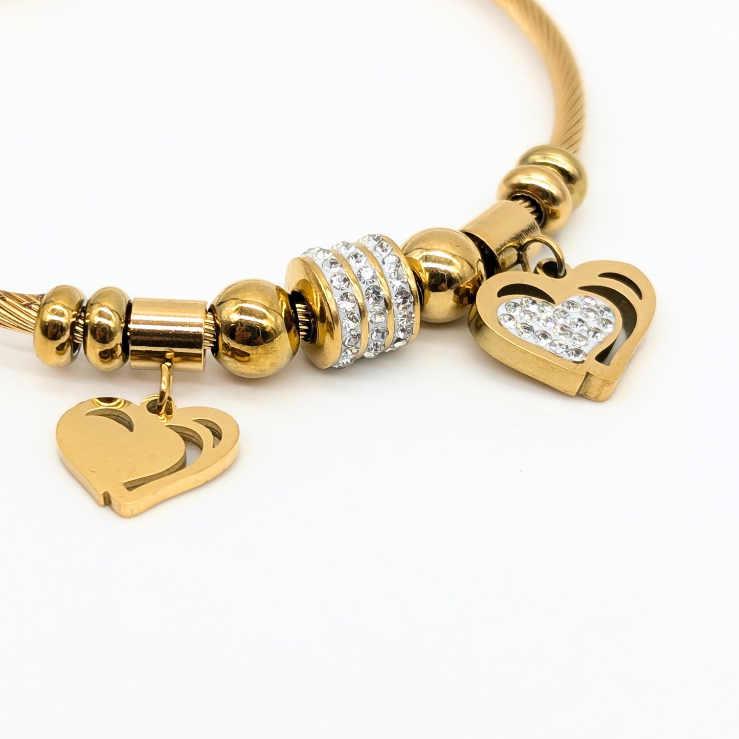 Gold bracelet with heart-shaped charms on a white background