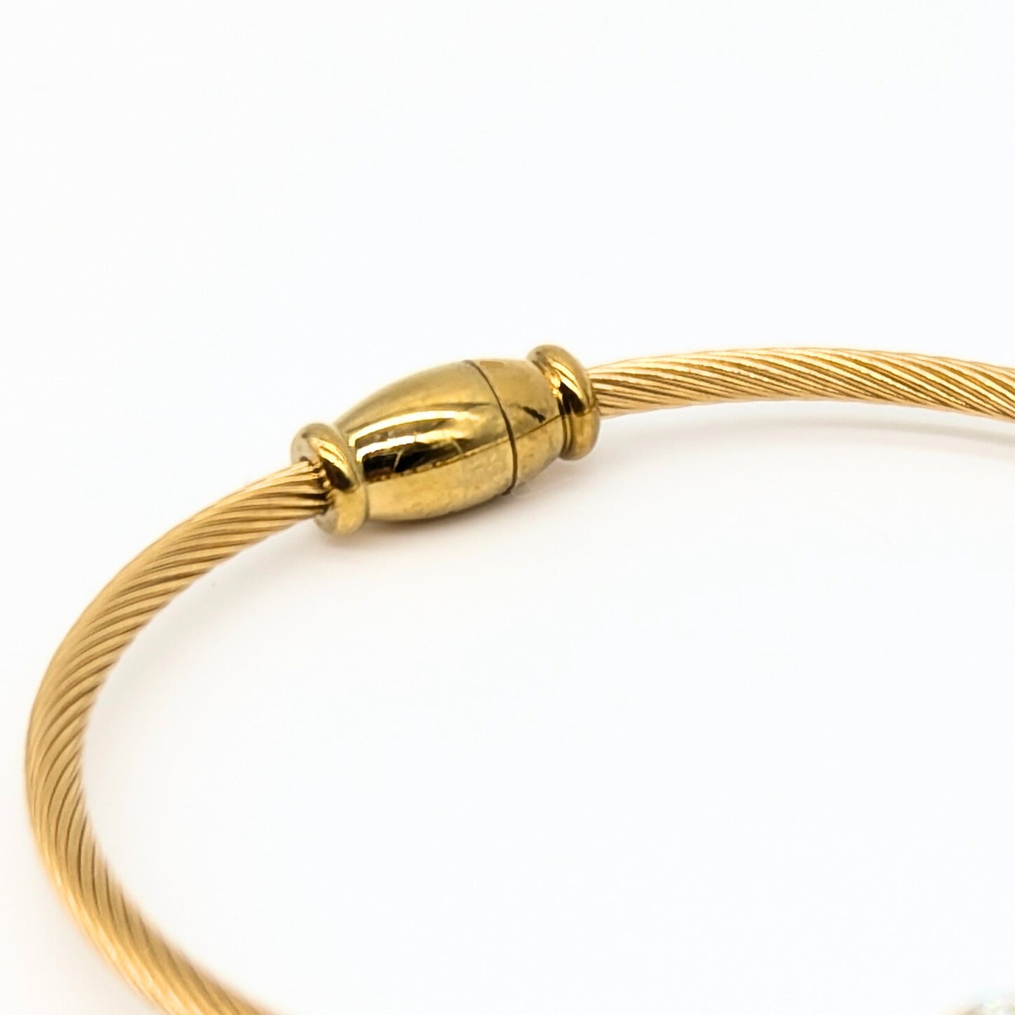 Gold bracelet with a gold magnetic clasp on a white background