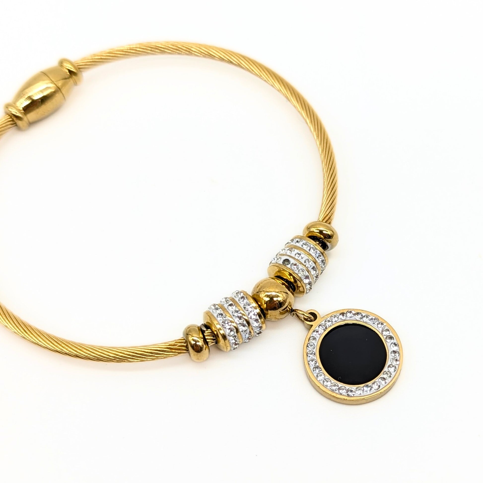 Magnetic clasp detail on gold-plated bracelet with black enamel charm