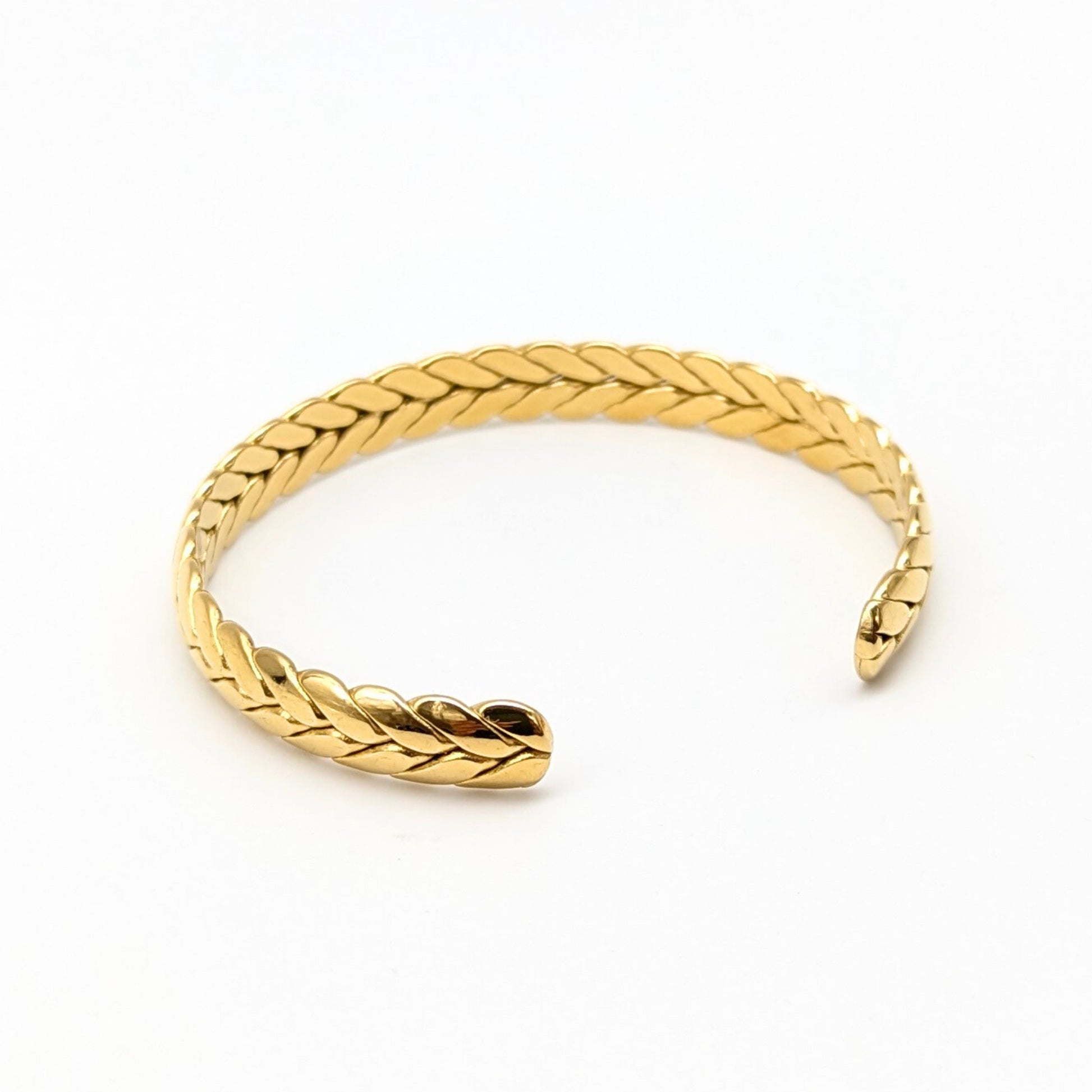 Angled view of open braided bracelet on white background