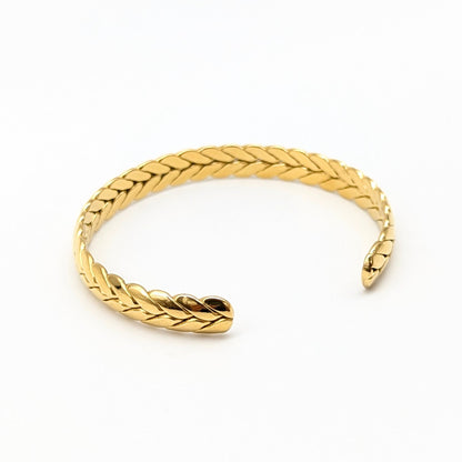 Angled view of open braided bracelet on white background