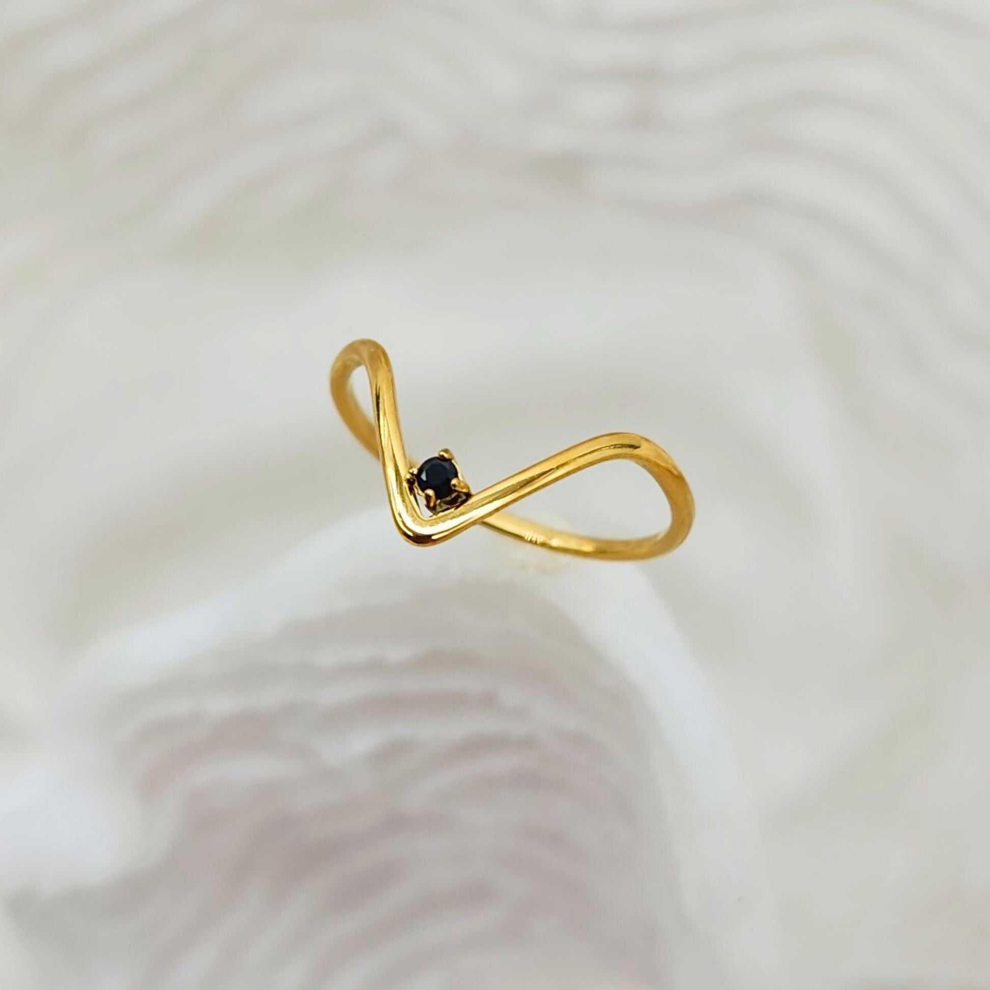 Minimalist gold V-shaped ring with petite black onyx stone, side angle