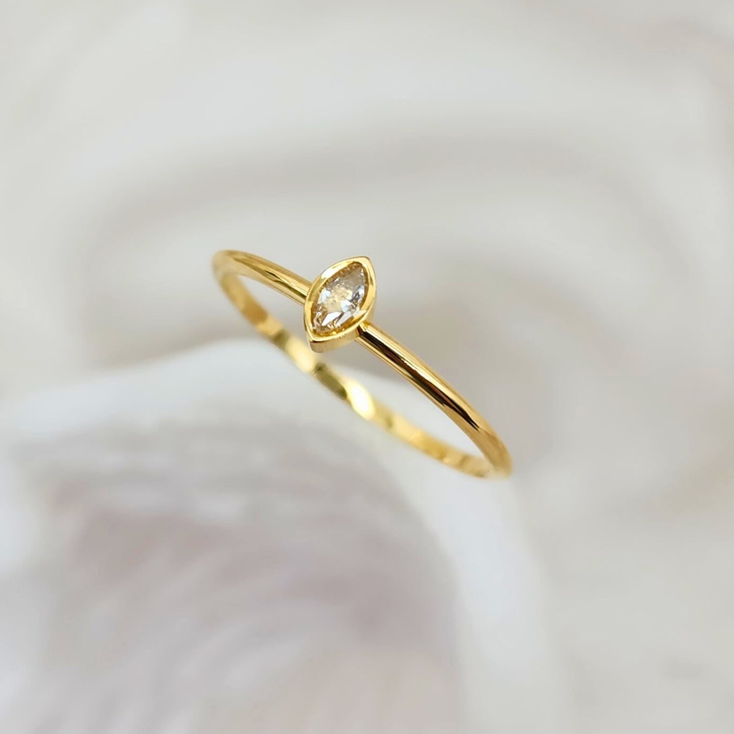Dainty gold ring with marquise-cut cubic zirconia solitaire, side view