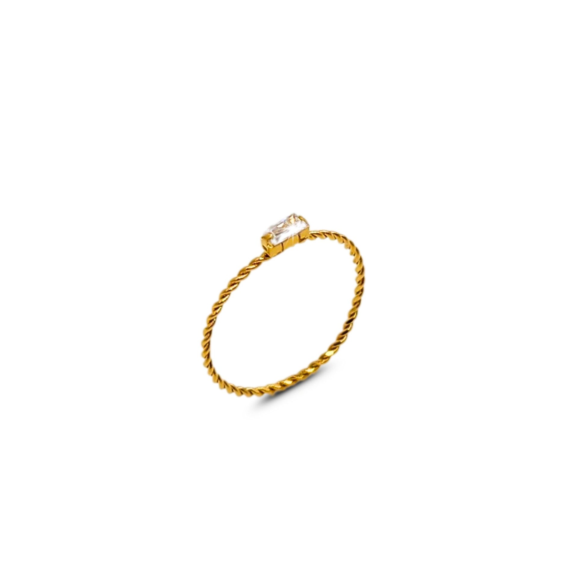 Minimalist twisted gold band ring with rectangular clear CZ stone, isolated on white