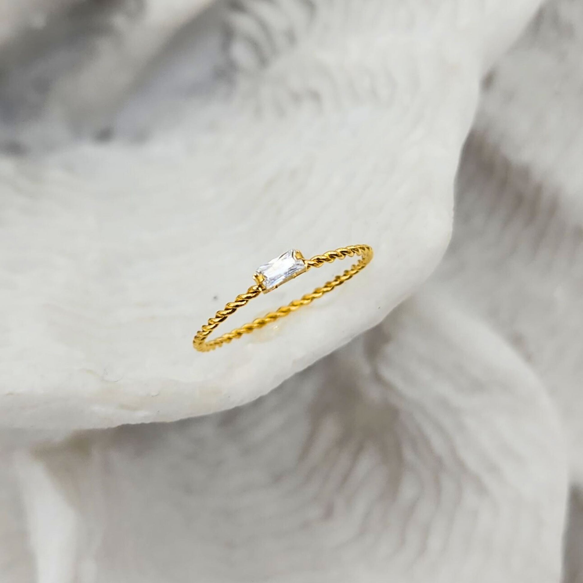 Dainty twisted gold ring with rectangular cubic zirconia set on natural shell