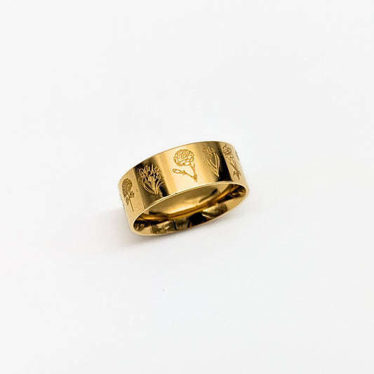 Gold ring with engraved floral designs on a white background