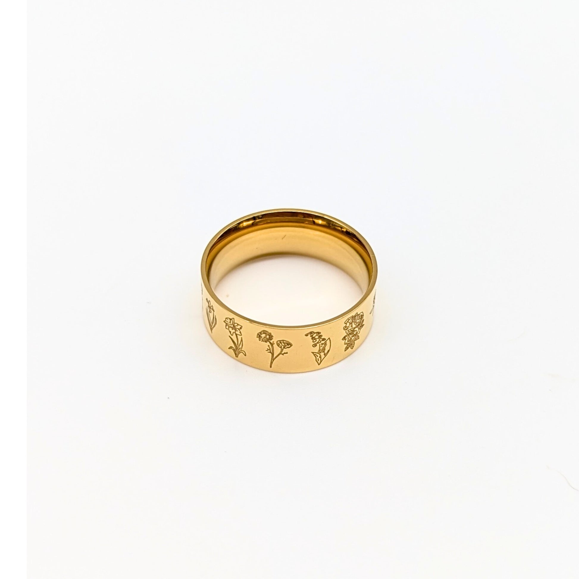 Gold ring with engraved floral designs on a white background