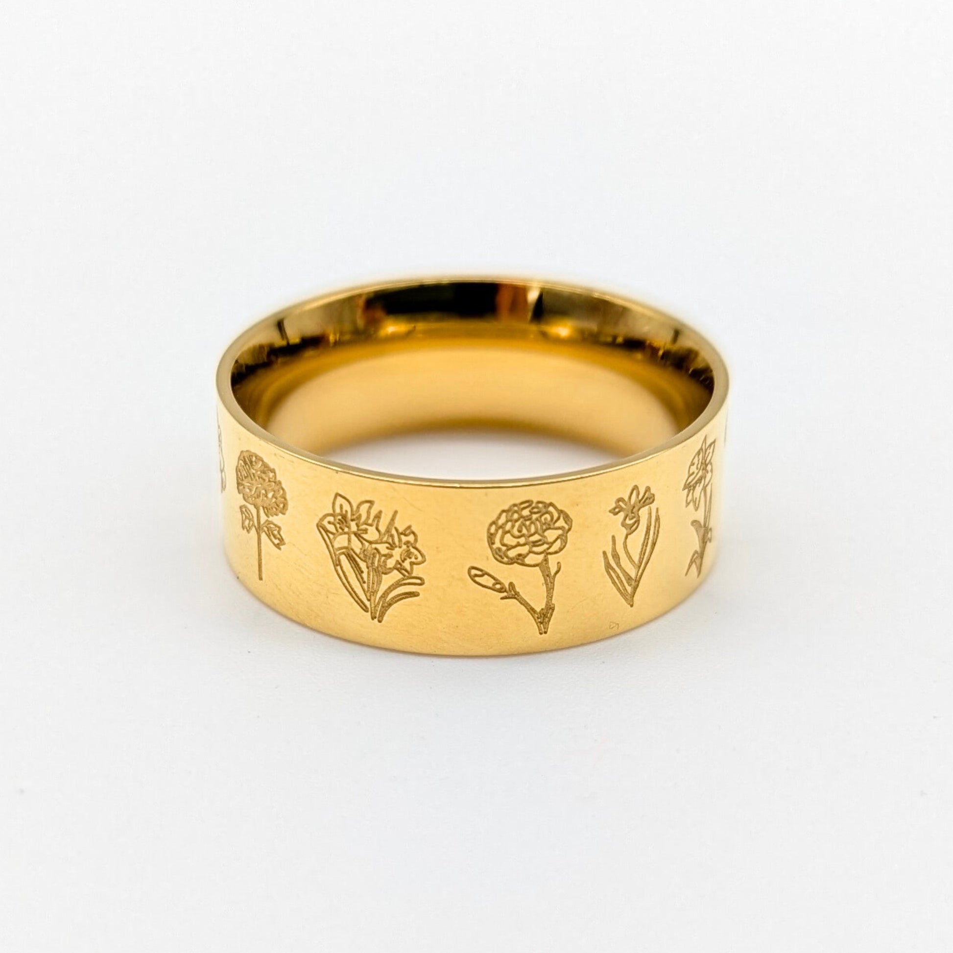 Gold ring with floral engravings on a white background