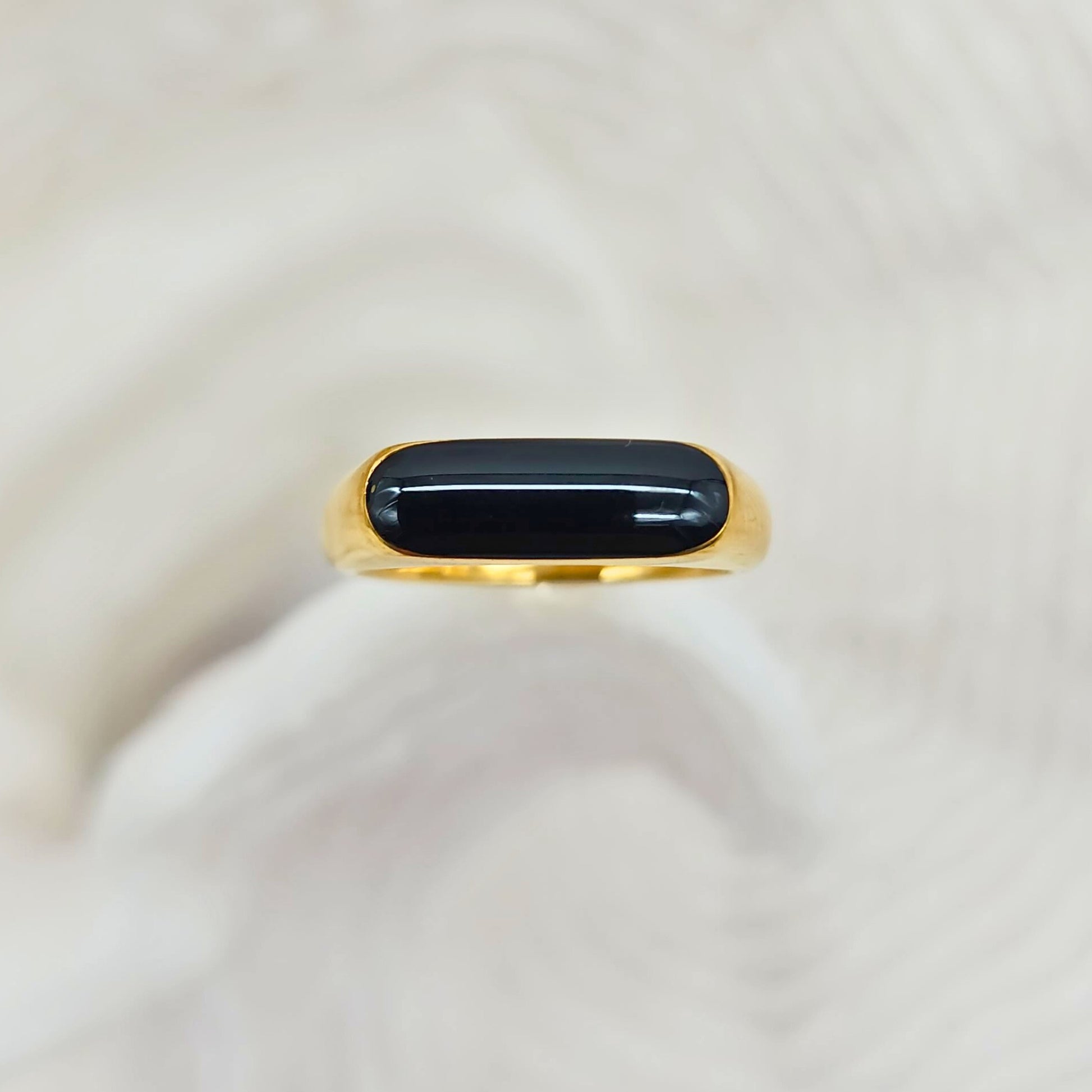 Minimalist gold ring with smooth rounded black center, front view