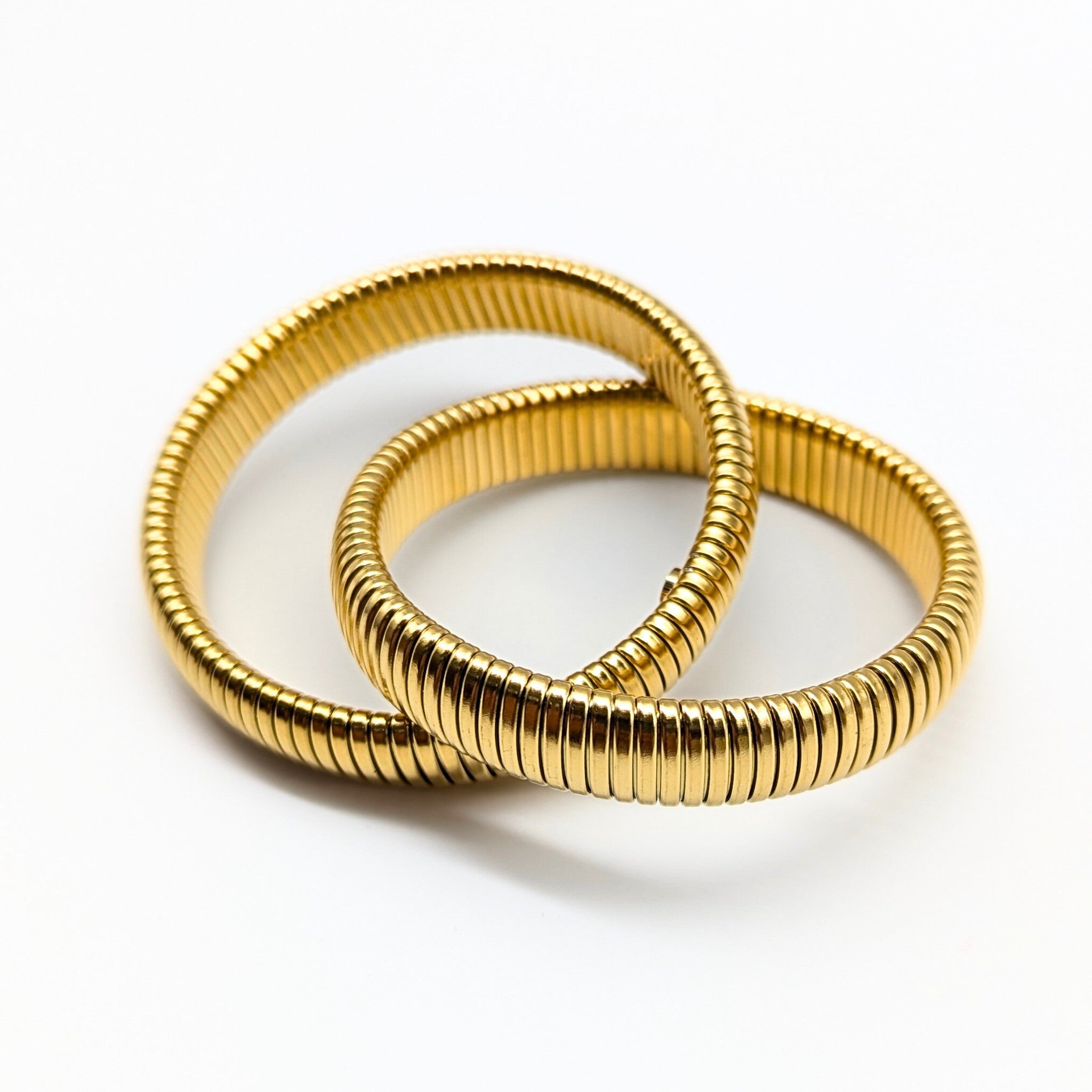 Flexible gold bangle set on white background